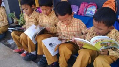 Anak Anak kelas 3 SDN 1 Purwasari sedang membaca buku di depan kelas